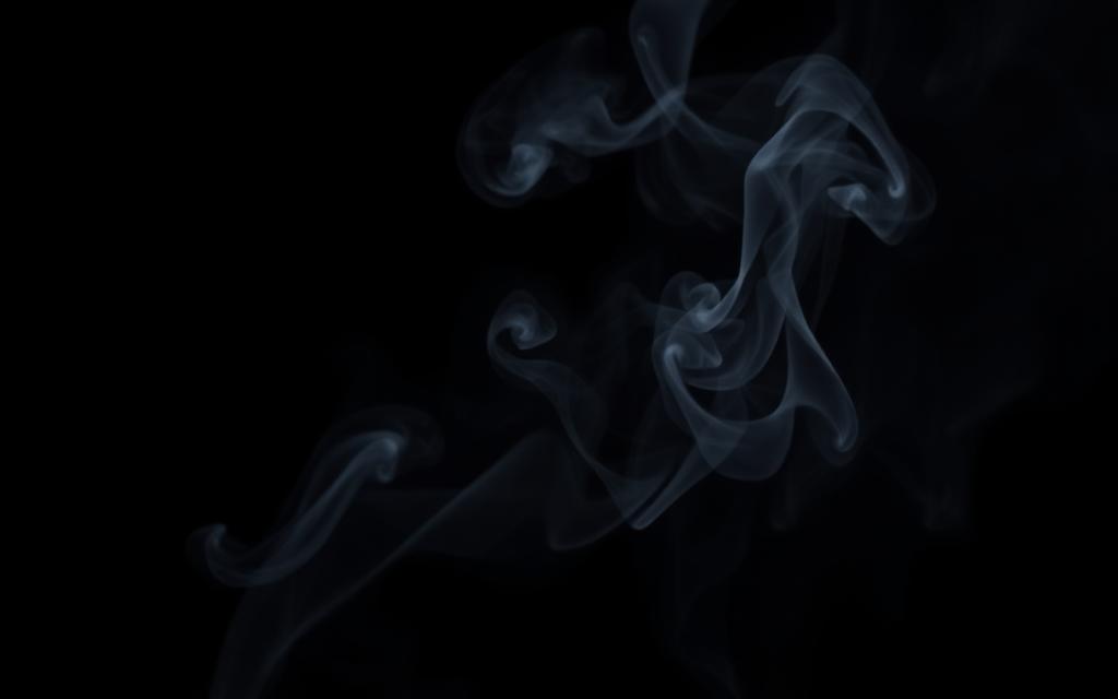Slow-drifting smoke and ash against a black void